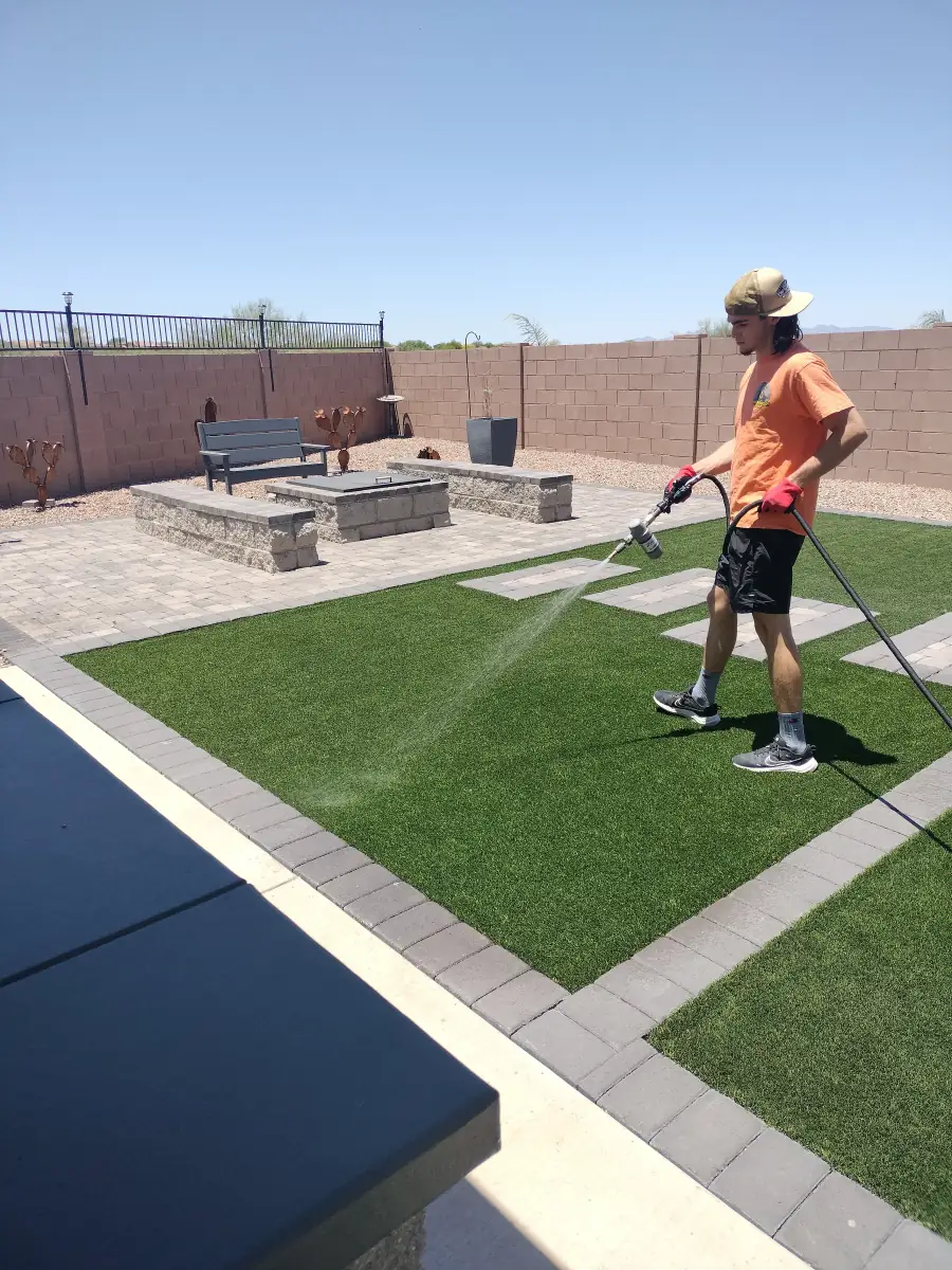 Scoop Doggy Logs technician spraying FRESHguard sanitizer on a Tucson turf yard